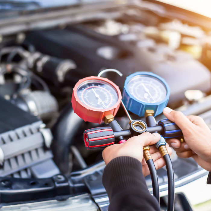 mechanic testing a/c levels in car
