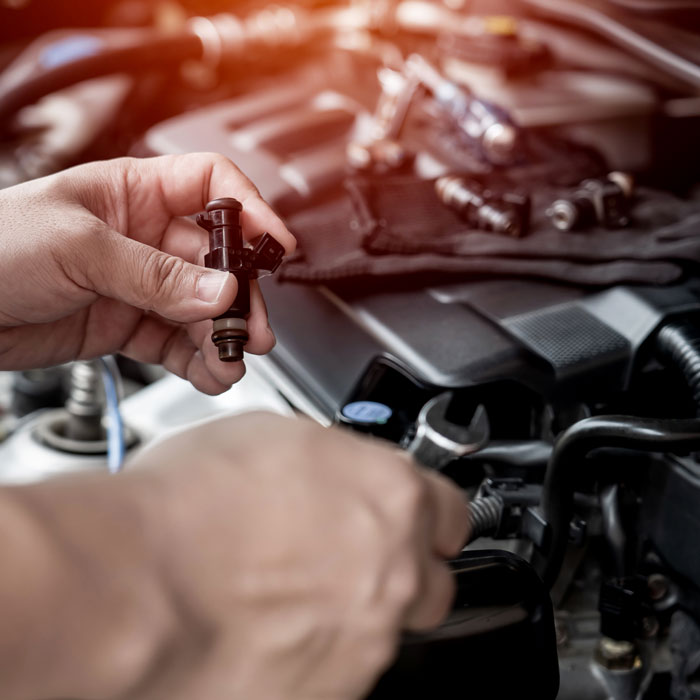 mechanic holding fuel injector