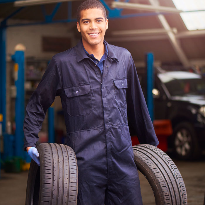 mechanic carrying 2 tires